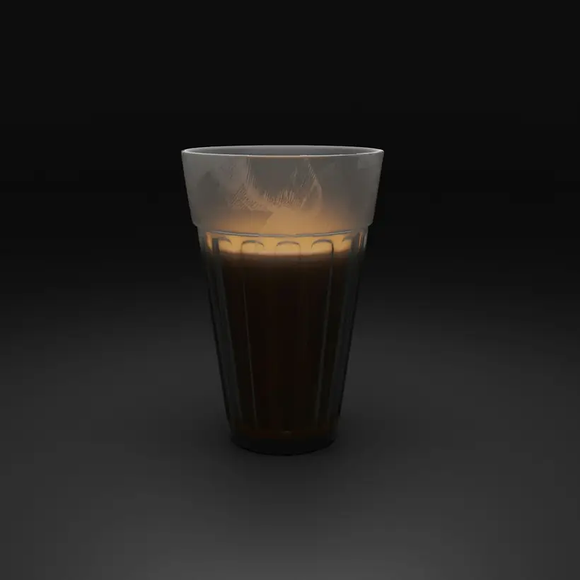 A glass of milky tea glowing in a dark room.